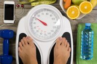 Healthy lifestyle concept with woman’s feet having perfect weight on bathroom scale